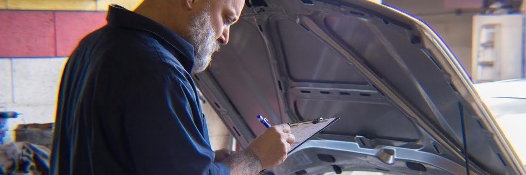 Guy writing on clipboard for a General Transmission check, transmission repair fallon