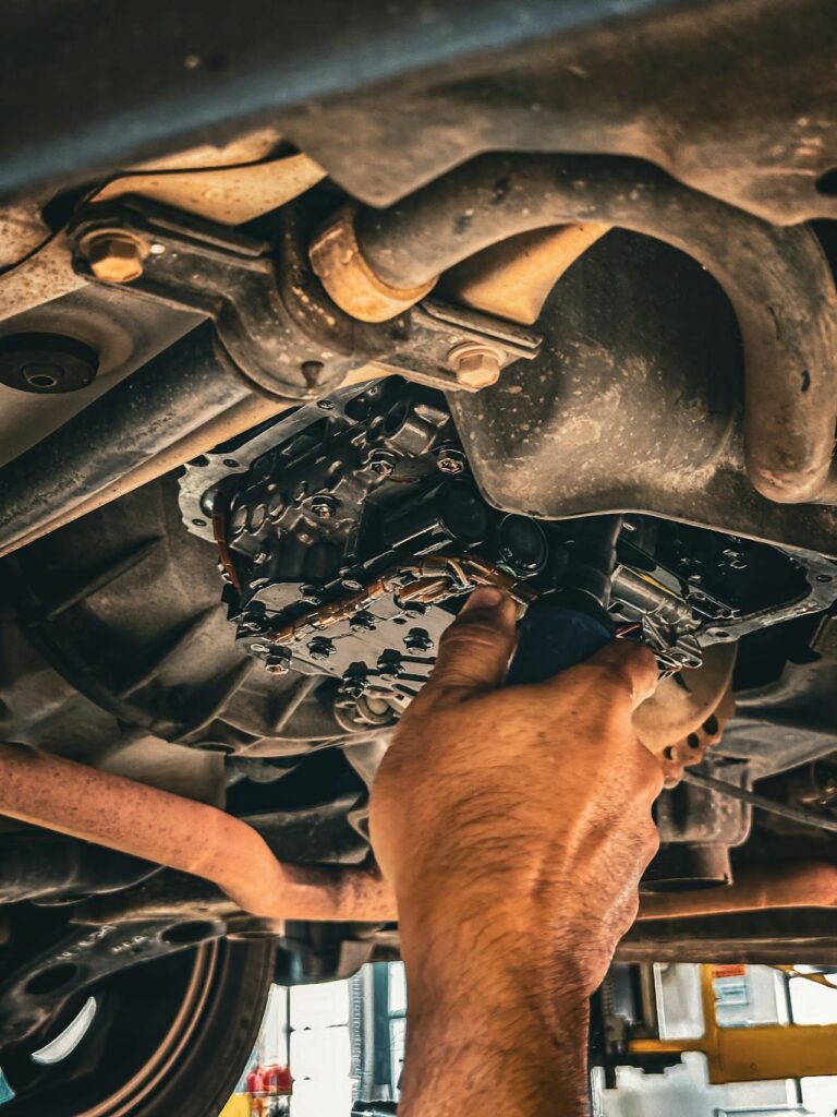 Close-up view of hands working on transmission components at a transmission shop in Reno.
