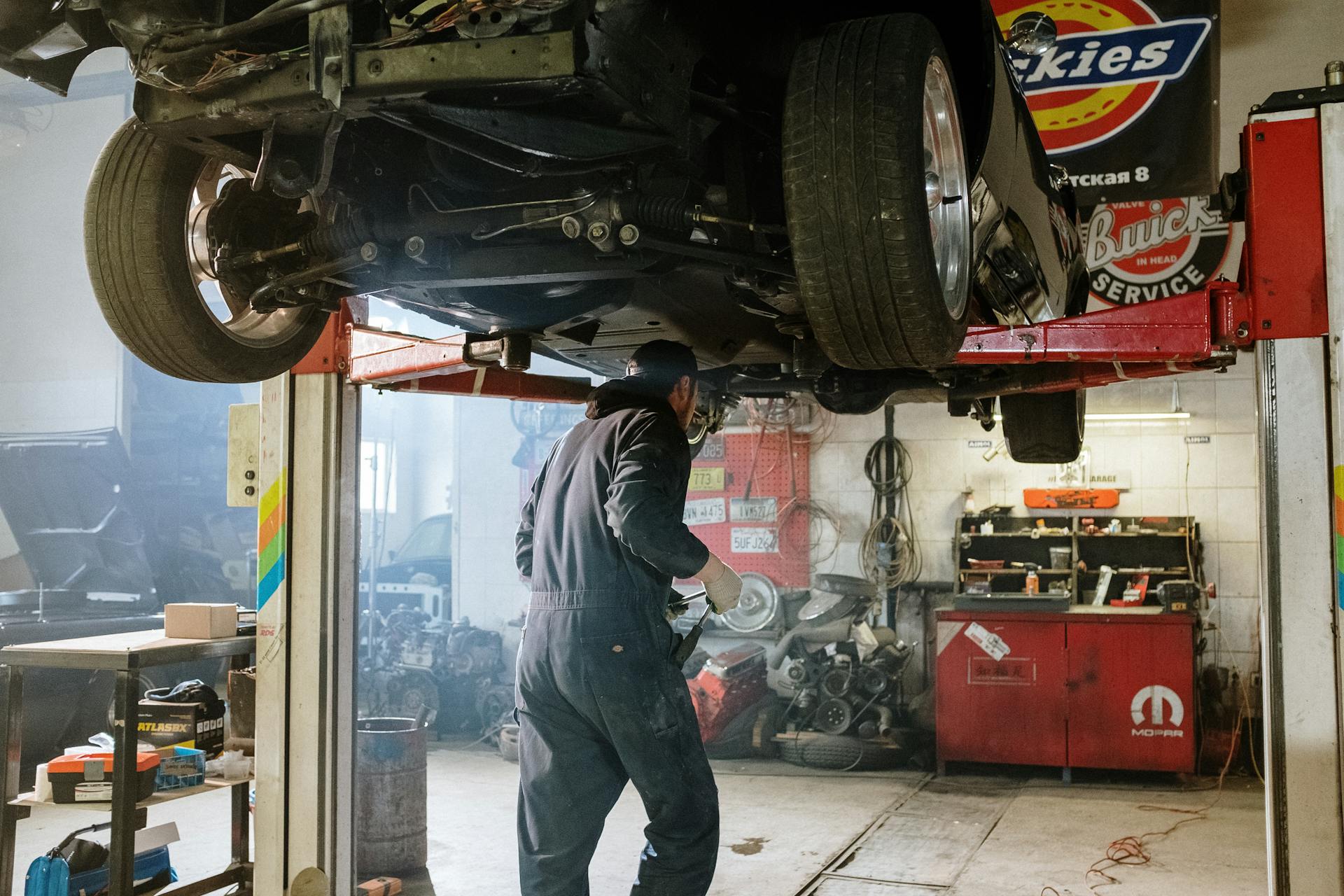 Mechanic inspecting drivetrain components during Heavy Duty Transmission repair while working under a lifted truck