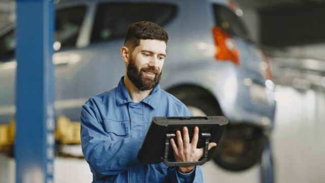 Transmission rebuild shop Reno technician smiling while working on vehicle repair